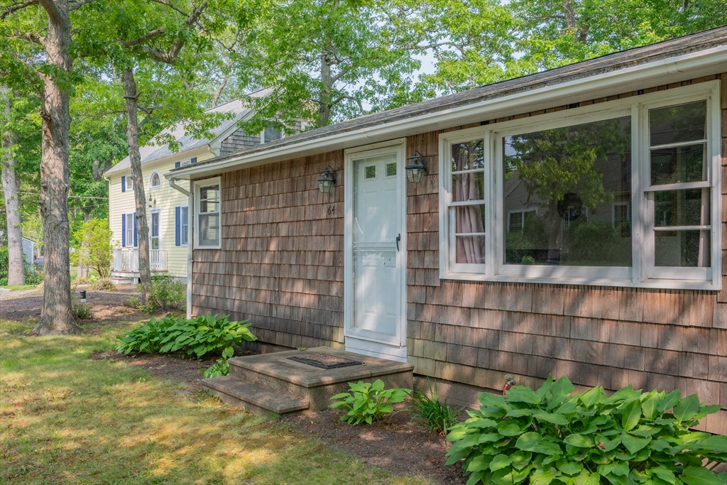 64 Uncle Percy's Road Mashpee, MA 02649 - Photo 3 of 33 a front view of a house with garden