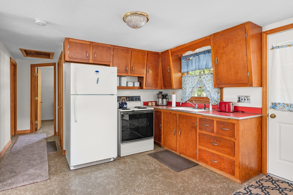 64 Uncle Percy's Road Mashpee, MA 02649 - Photo 9 of 33 a kitchen with stainless steel appliances a refrigerator and a stove top oven