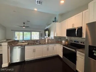 a kitchen with stainless steel appliances granite countertop a sink and stove top oven