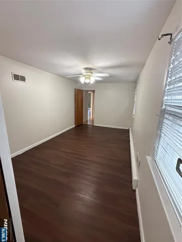 a view of an empty room with wooden floor and staircase