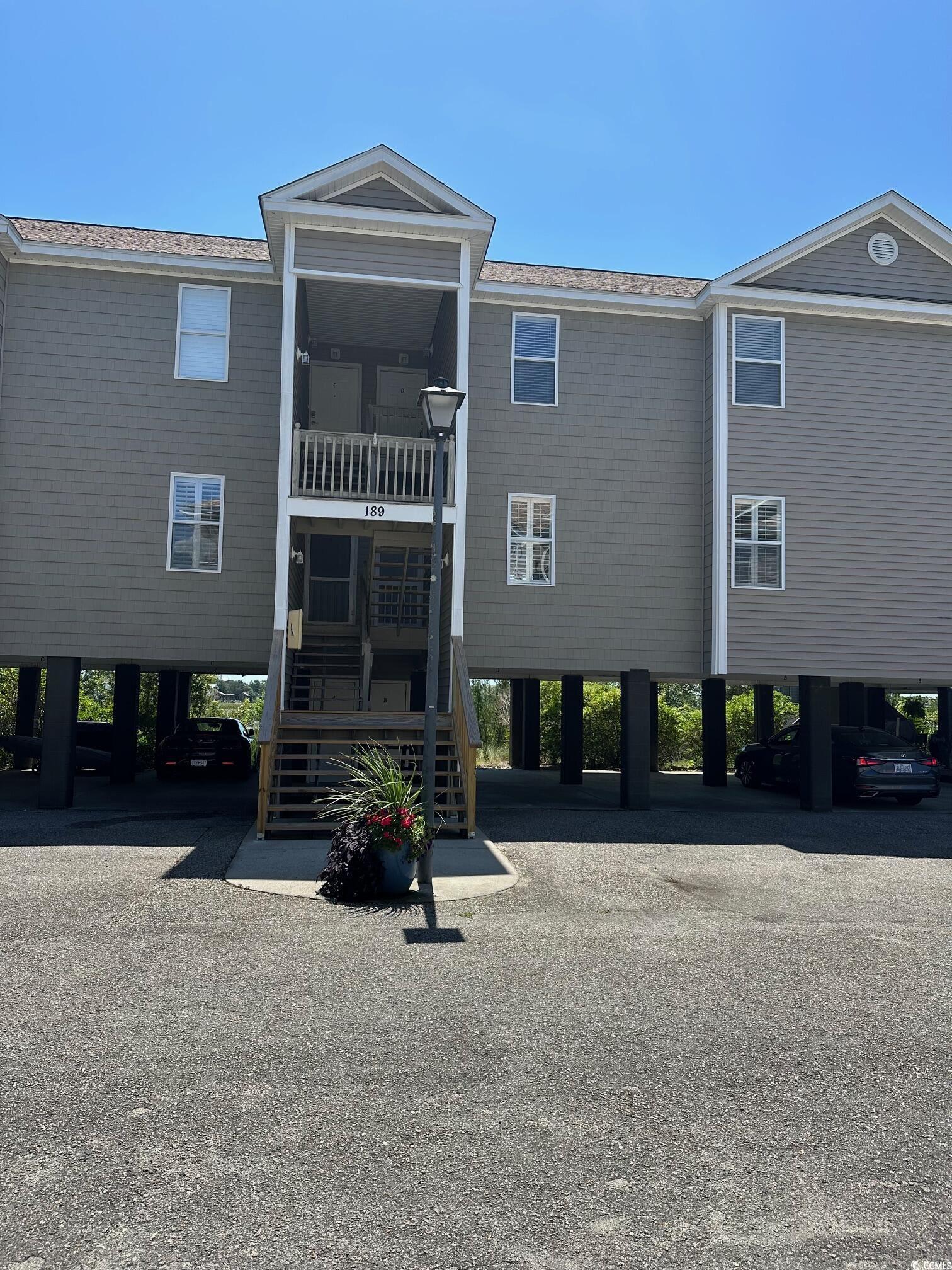 View of building exterior with a carport and stair