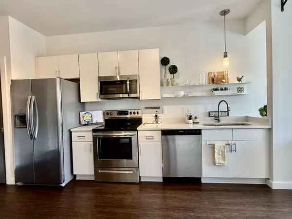 a kitchen with stainless steel appliances a stove a sink and a refrigerator