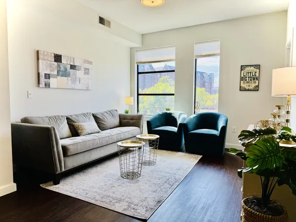 a living room with furniture potted plant and wooden floor