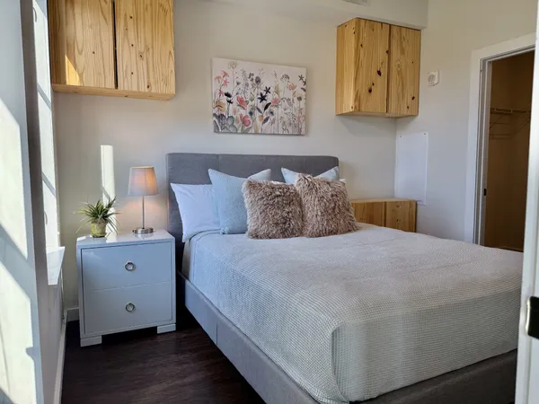 a spacious bedroom with a bed and painting on the wall