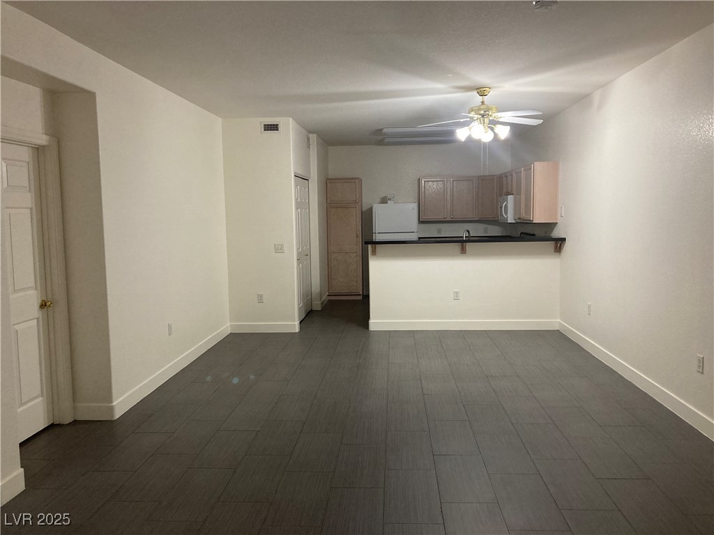 2001 Quartz Cliff Street, Unit 103 Las Vegas, NV 89117 - Photo 7 of 35 Unfurnished living room with ceiling fan and dark wood-style flooring