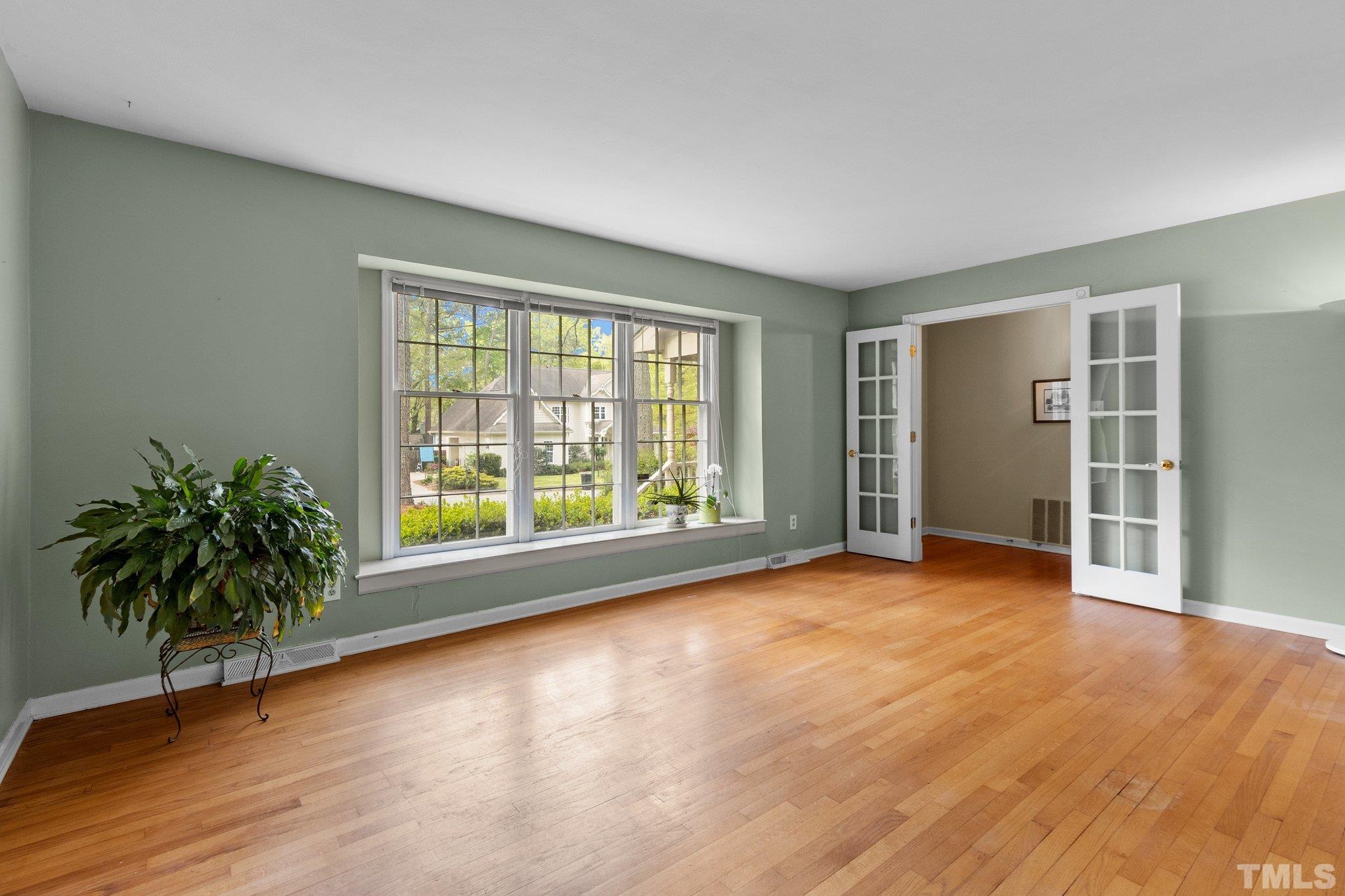 1603 Fountain Ridge Road Chapel Hill, NC 27517 - Photo 7 of 28 an empty room with wooden floor and windows