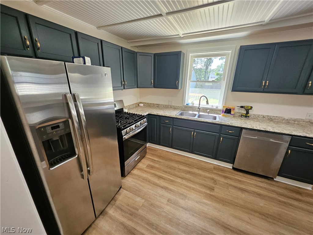 753 West River Road North Elyria, OH 44035 - Photo 5 of 28 Renovated kitchen featuring dark shaker-style cabinetry with gold hardware, light-colored speckled countertops, and stainless steel appliances