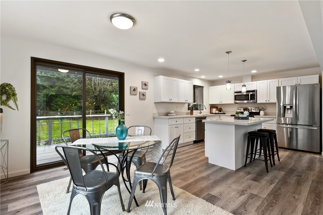 4908 200th Street Southeast Bothell, WA 98012 - Photo 9 of 29 a view of a dining room with furniture a kitchen and chandelier