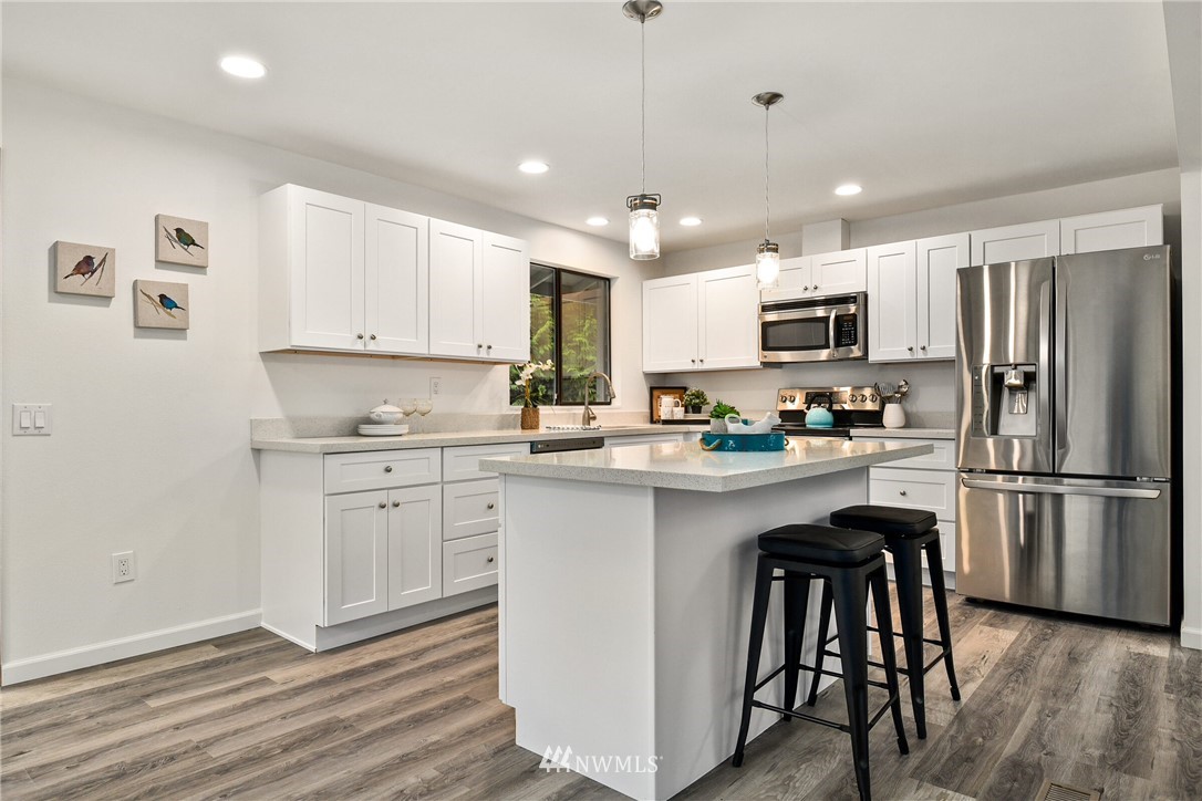 4908 200th Street Southeast Bothell, WA 98012 - Photo 10 of 29 a kitchen with granite countertop a refrigerator stove microwave and cabinets