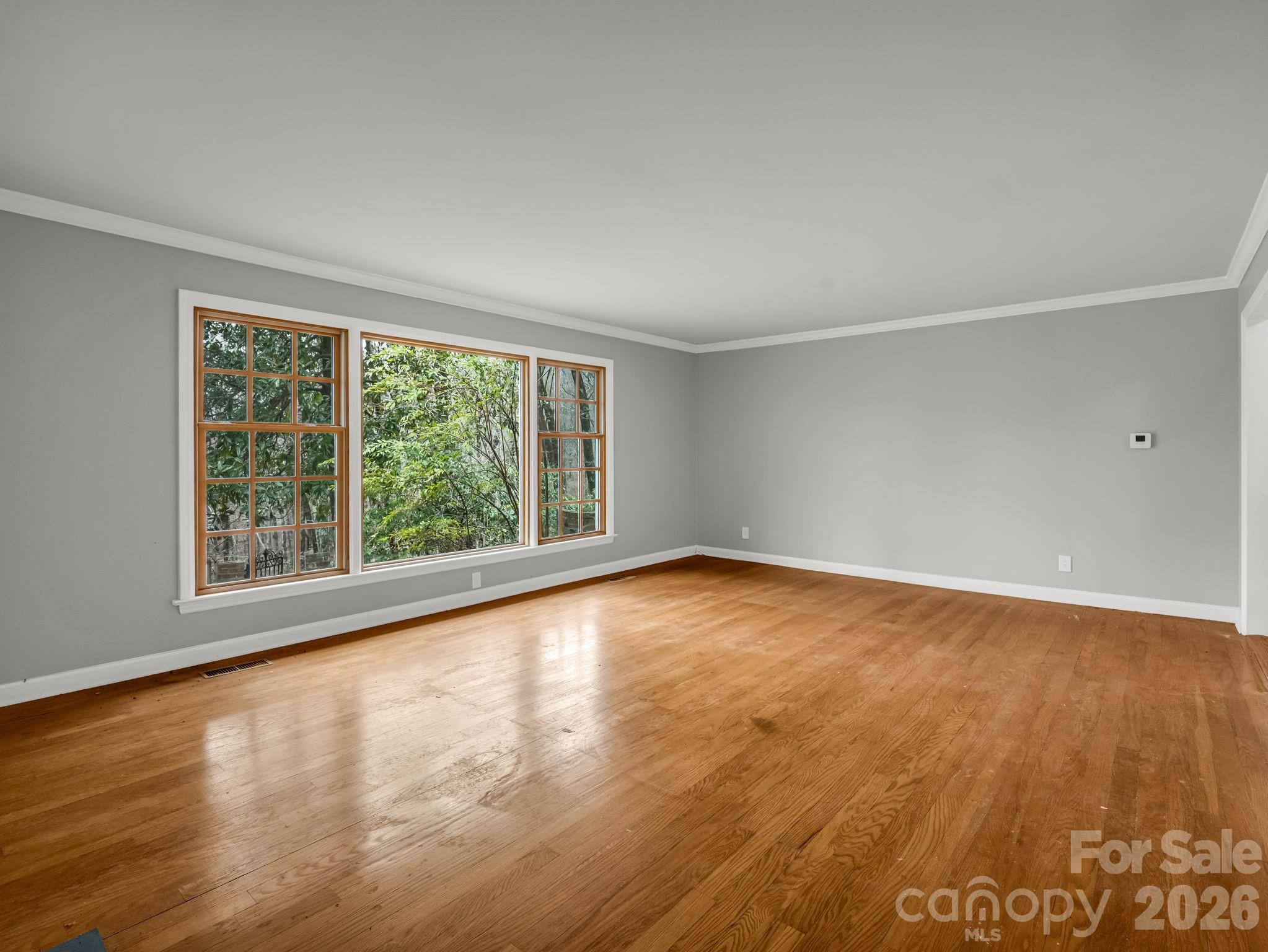 117 Hummingbird Lane Columbus, NC 28722 - Photo 15 of 32 a view of an empty room with wooden floor and a window