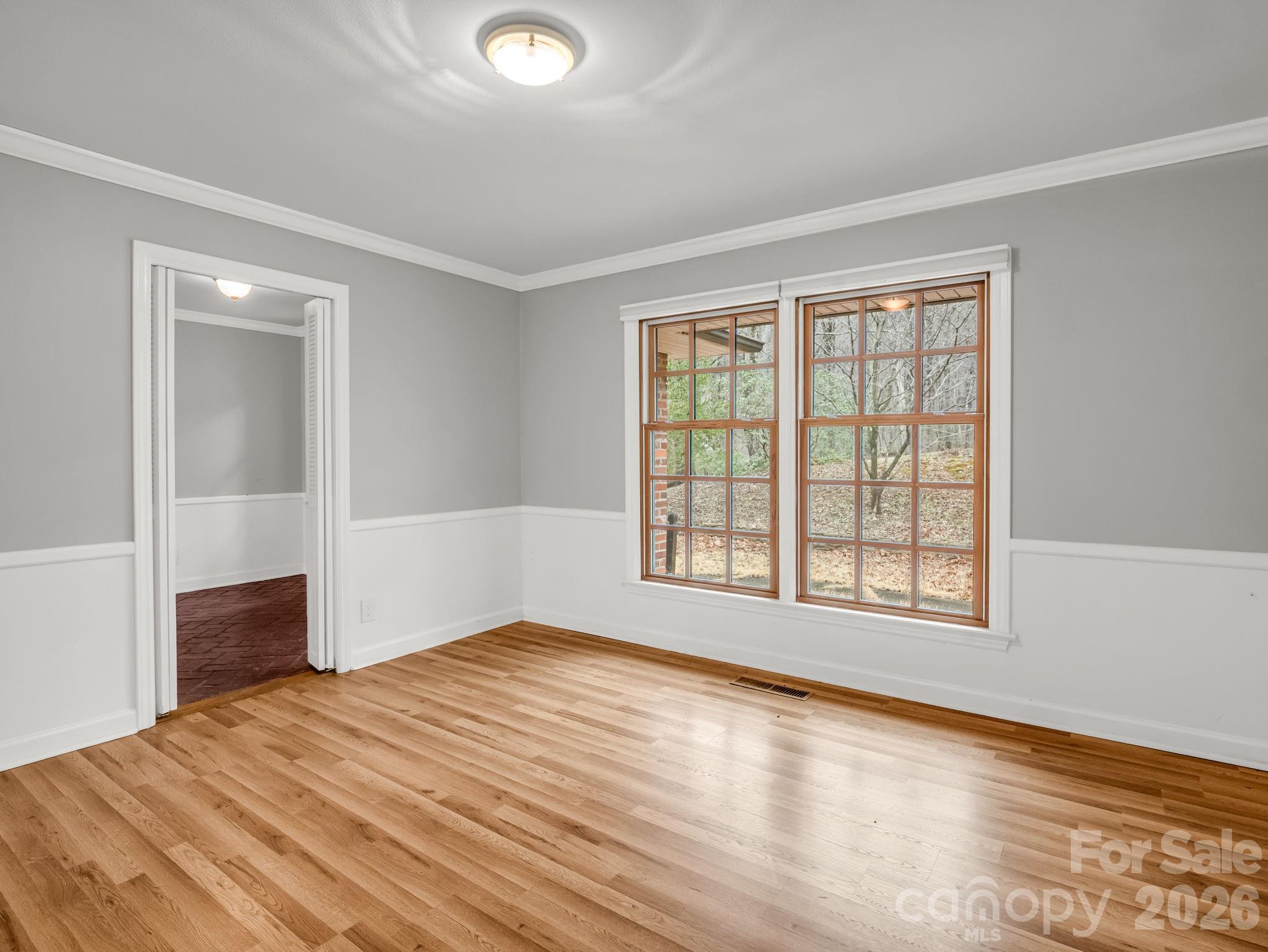 117 Hummingbird Lane Columbus, NC 28722 - Photo 19 of 32 an empty room with wooden floor and windows