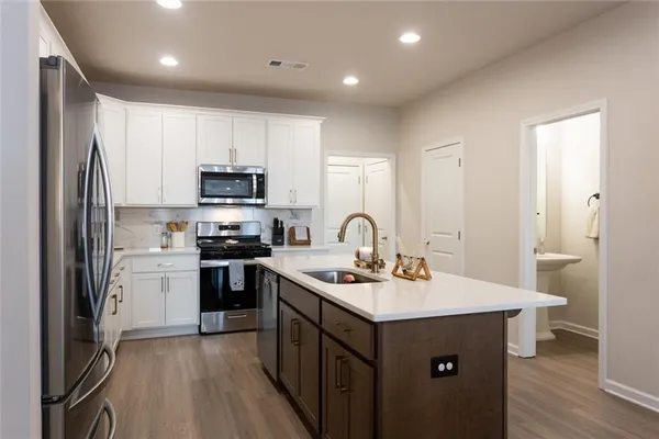 a kitchen with a sink stainless steel appliances and white cabinets