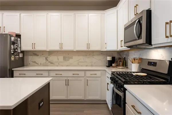 a kitchen with stainless steel appliances granite countertop white cabinets sink and dishwasher