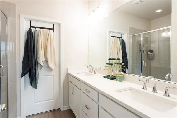 a spacious bathroom with a double vanity sink a mirror and shower