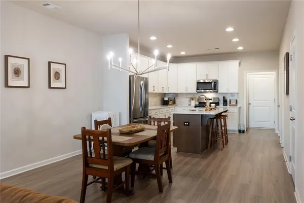 a kitchen with kitchen island white cabinets and stainless steel appliances