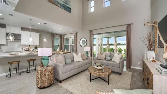 a living room with furniture kitchen view and a large window