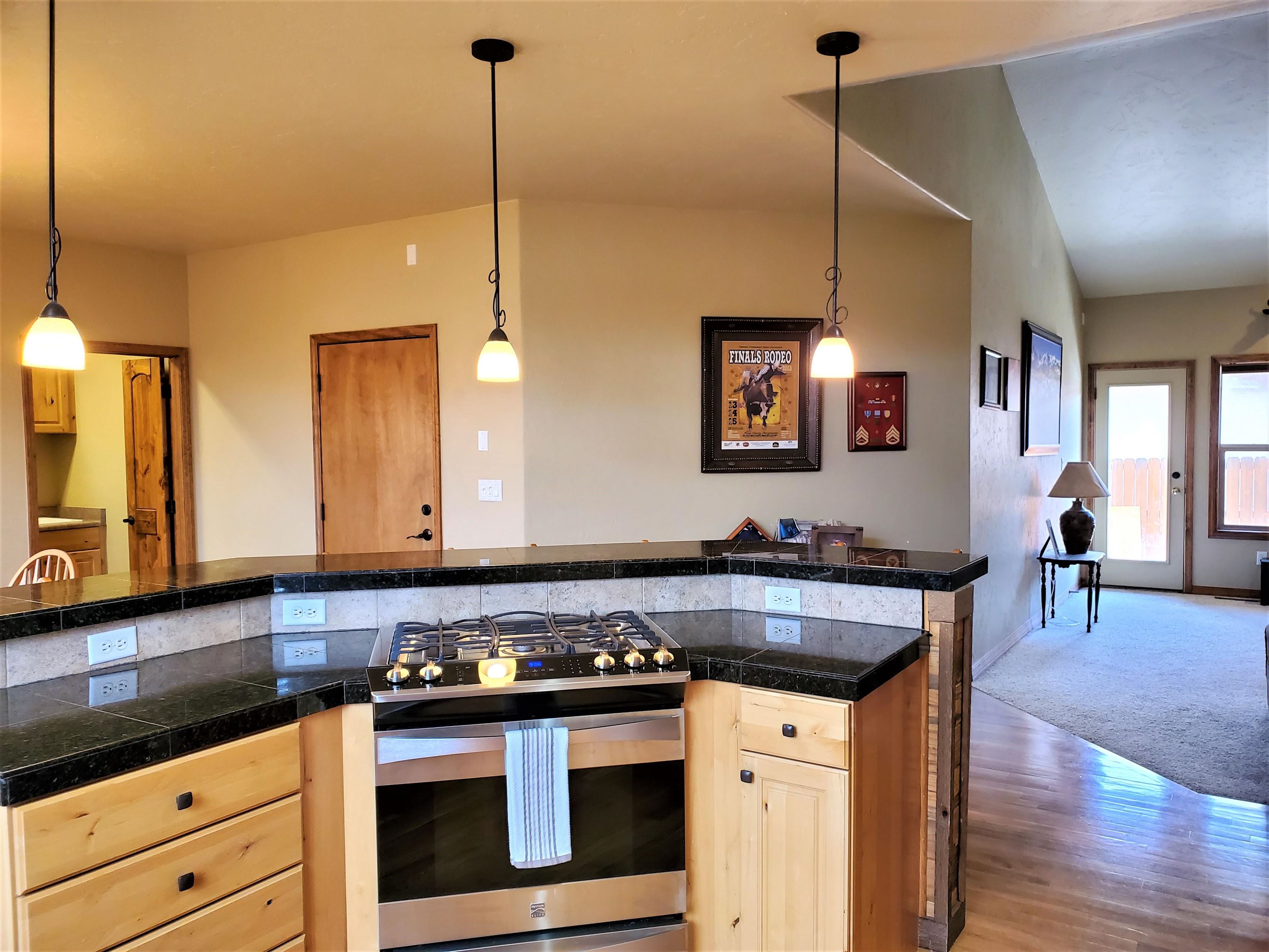 800 Esprit Lane Fruita, CO 81521 - Photo 12 of 38 a kitchen with stainless steel appliances granite countertop a stove a sink and a wooden floor