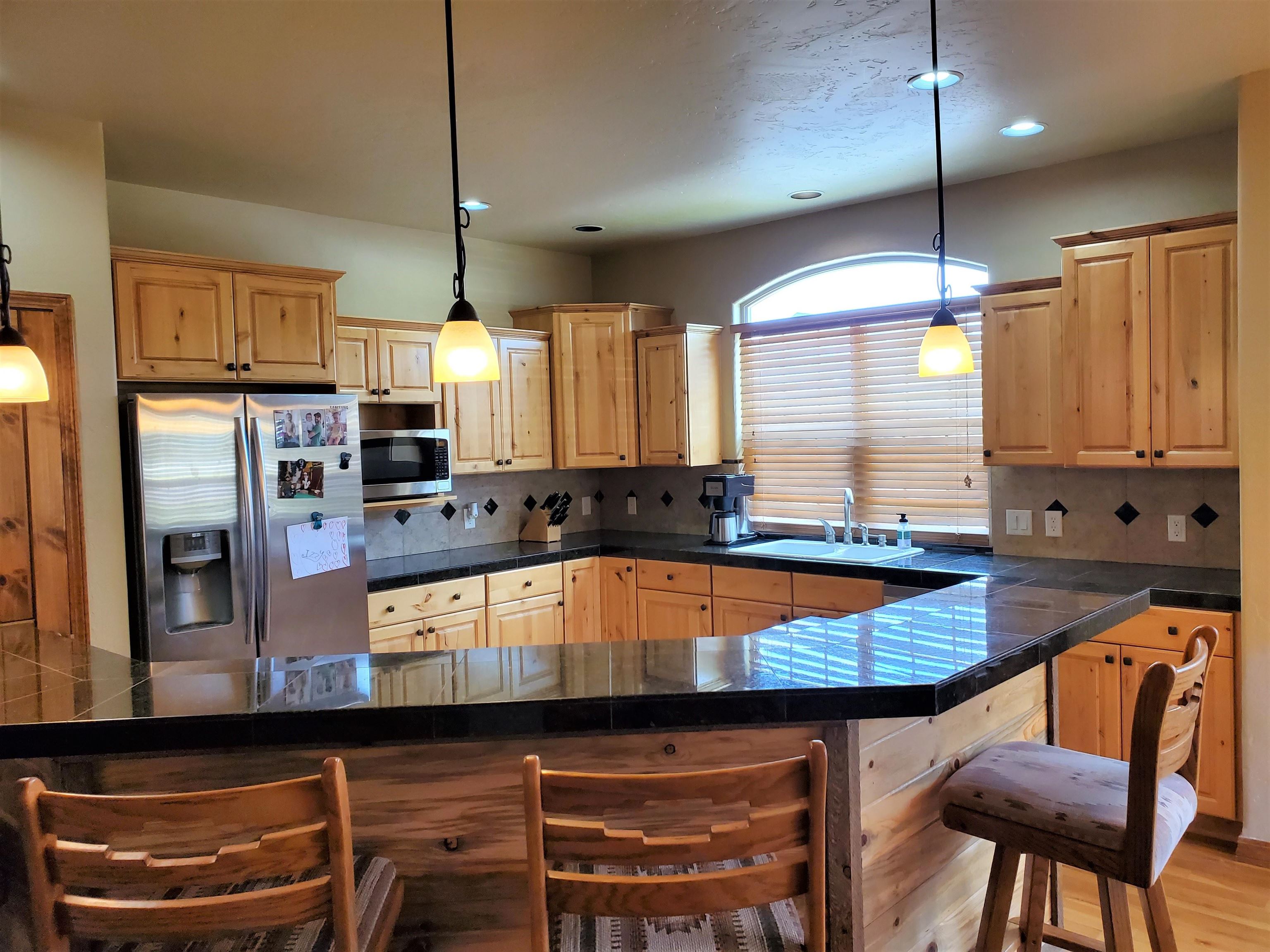 800 Esprit Lane Fruita, CO 81521 - Photo 13 of 38 a kitchen with granite countertop a stove a sink and a refrigerator