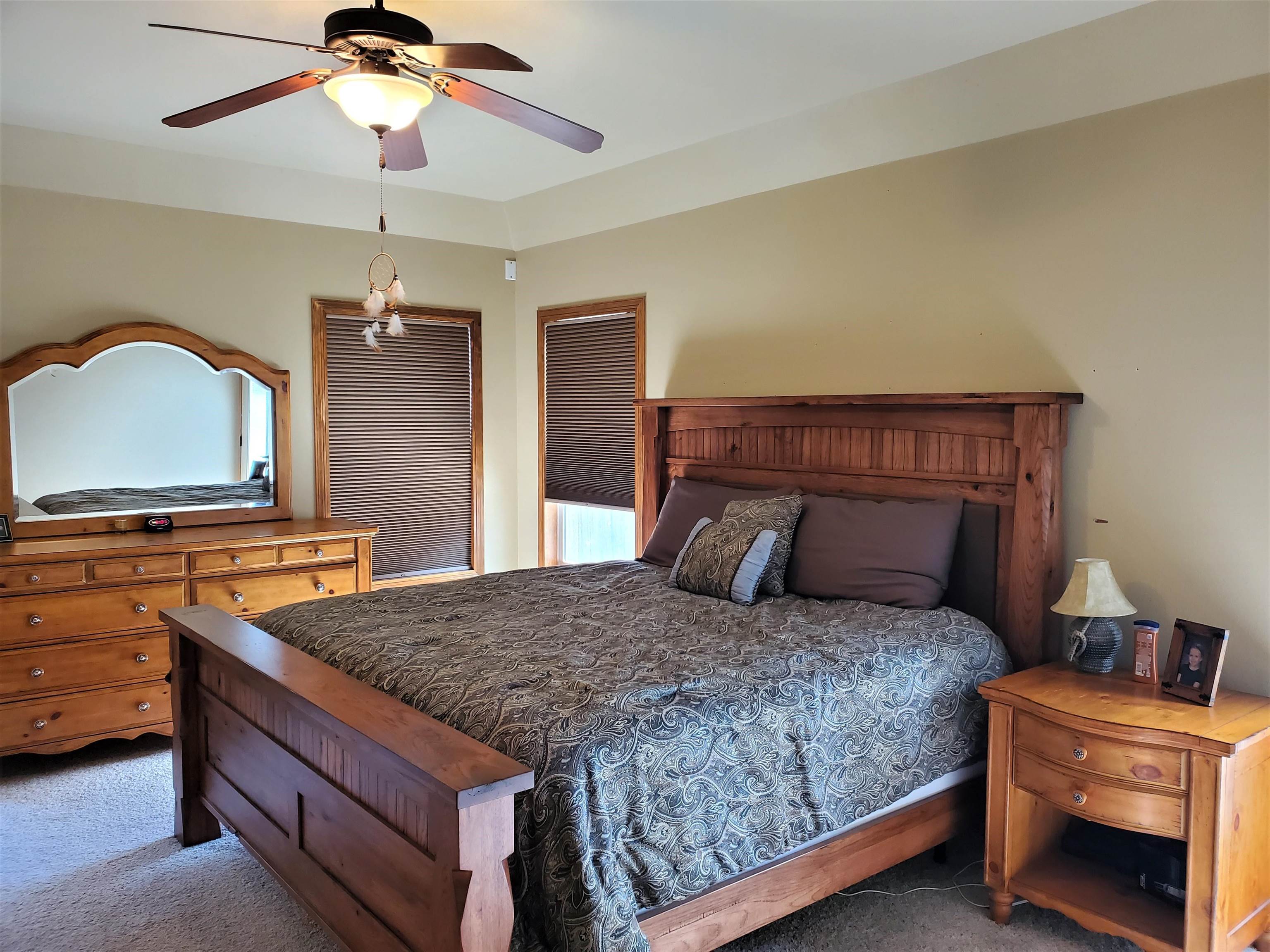 800 Esprit Lane Fruita, CO 81521 - Photo 17 of 38 a bedroom with a bed and a chandelier