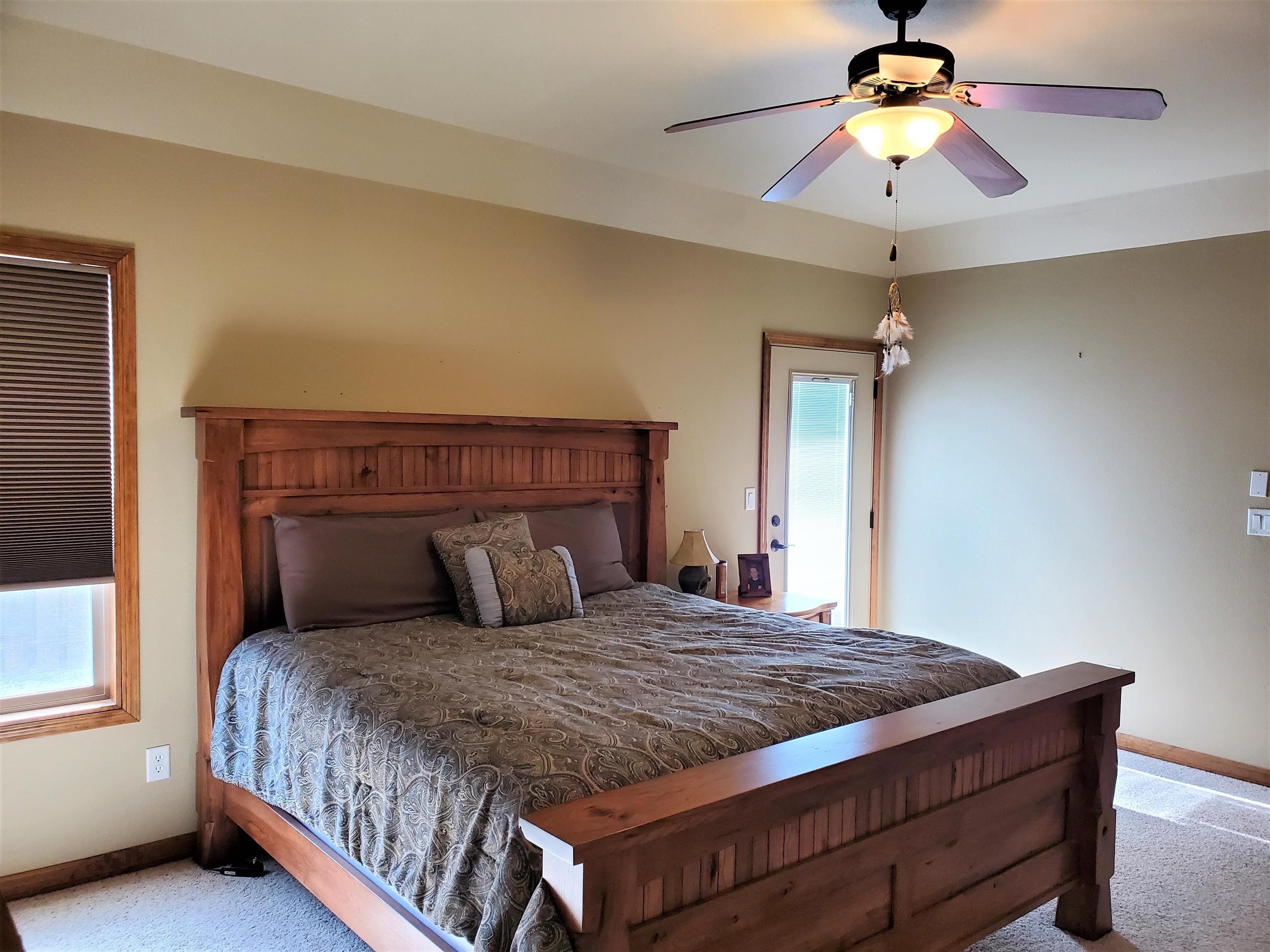 800 Esprit Lane Fruita, CO 81521 - Photo 18 of 38 a bedroom with a large bed and a chandelier