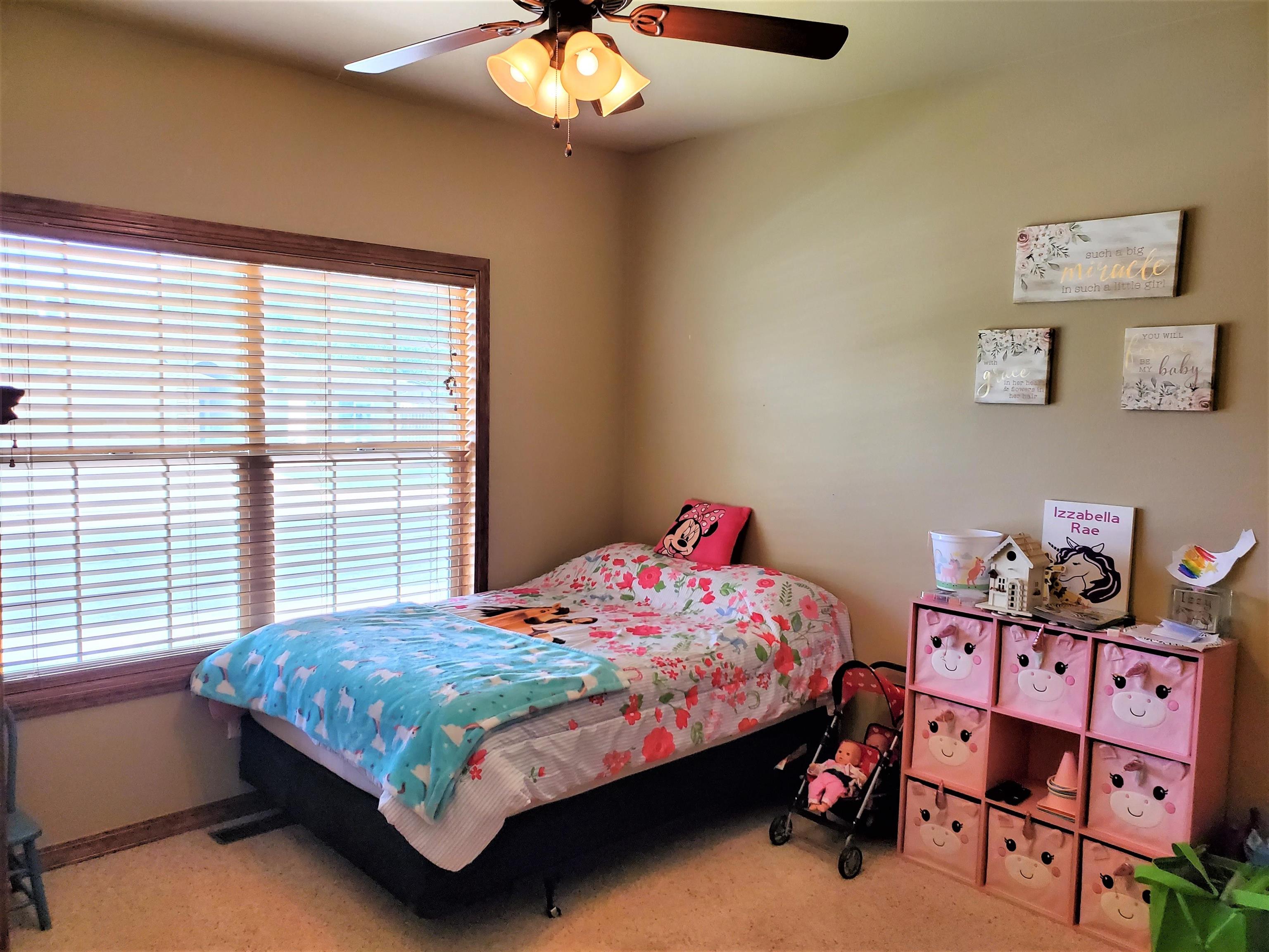 800 Esprit Lane Fruita, CO 81521 - Photo 23 of 38 a bedroom with a bed and a chandelier