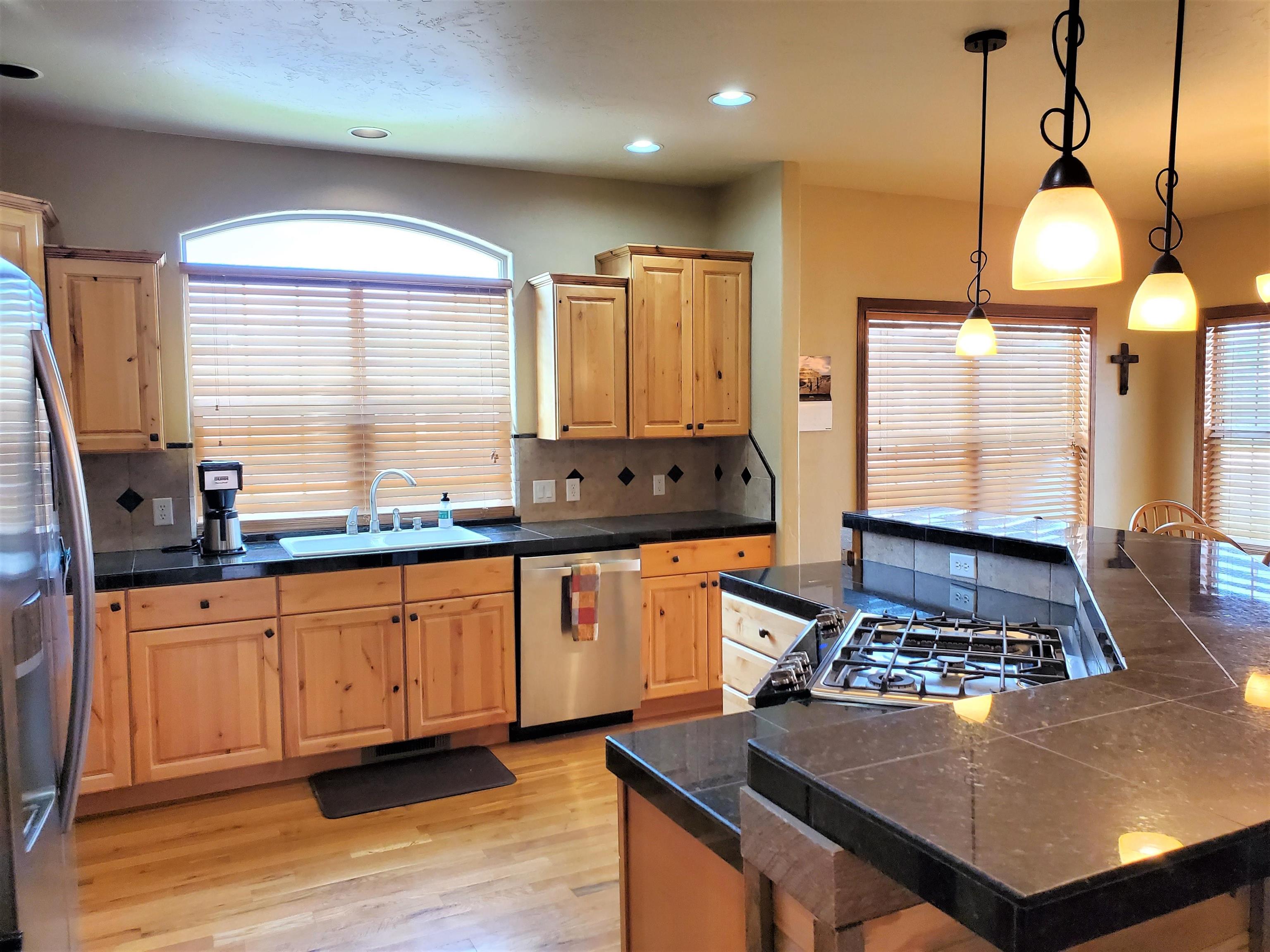800 Esprit Lane Fruita, CO 81521 - Photo 10 of 38 a kitchen with stainless steel appliances a sink a stove a refrigerator white cabinets and wooden floor