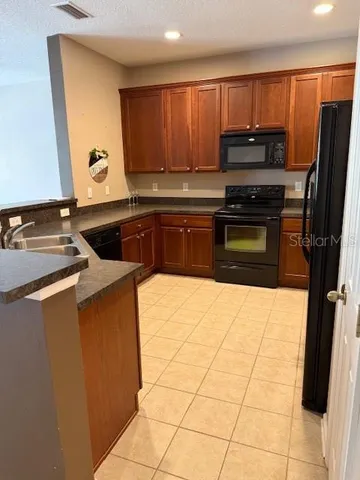 a kitchen with a sink a stove top oven a refrigerator and cabinets