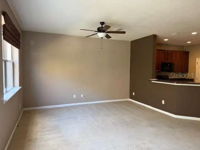 an empty room with a window and a ceiling fan