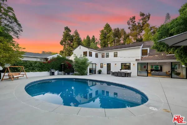 a swimming pool with outdoor seating and yard