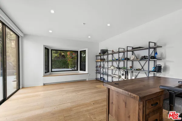 a living room with a wooden floor and a window