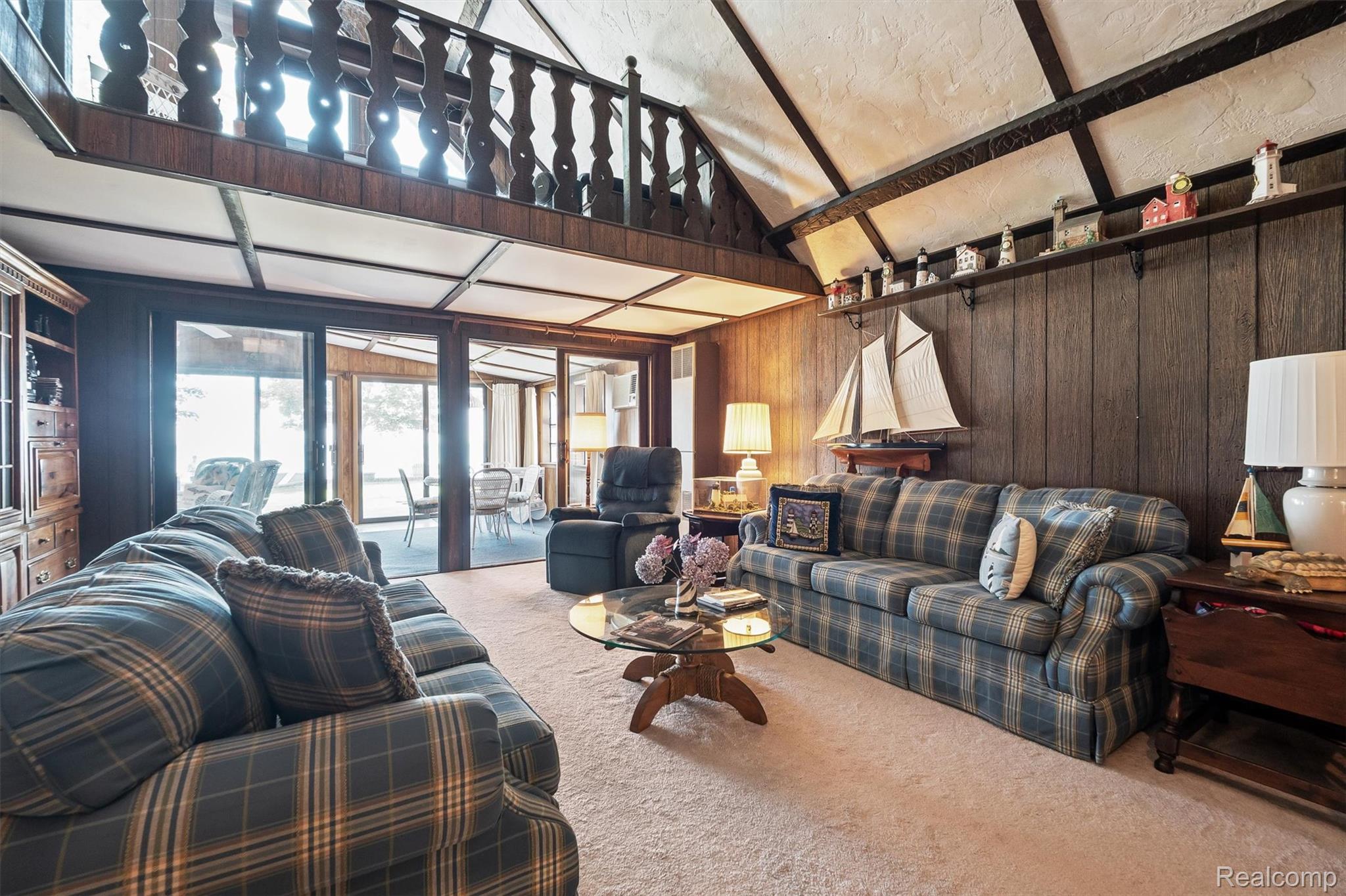 5892 Port Austin Road Caseville, MI 48725 - Photo 11 of 42 Carpeted living room with wood walls and high vaulted ceiling