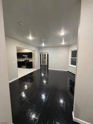 a view of empty room with wooden floor