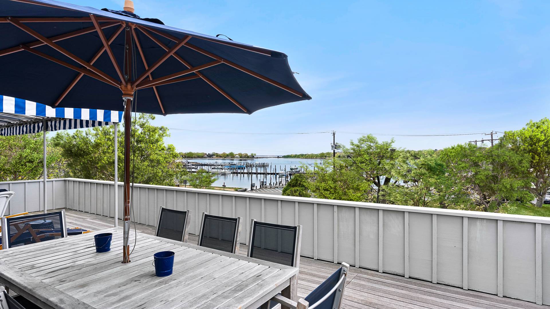 18 Bridge Street, Unit 4D Sag Harbor, NY 11963 - Photo 6 of 16 a roof deck with table and chairs under an umbrella