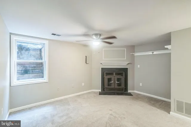 an empty room with fireplace and windows
