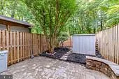 a backyard of a house with lawn chairs and wooden fence