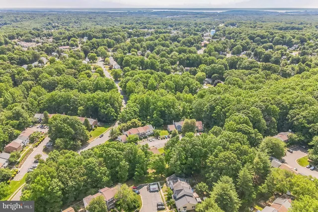 an aerial view of a houses with a yard and mountain