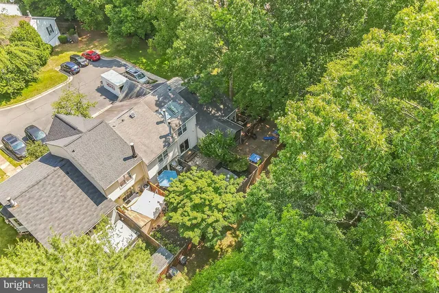 an aerial view of residential house with outdoor space and trees all around