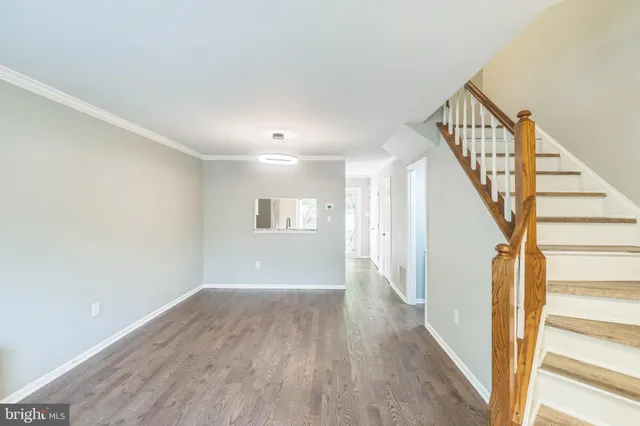 a view of a hallway with wooden floor and staircase