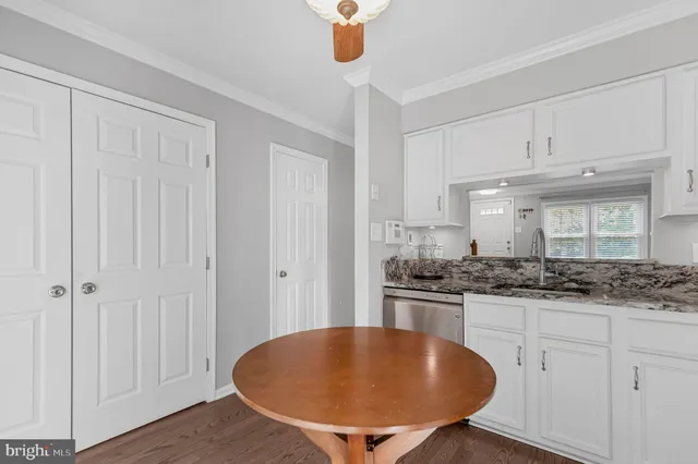 a room with stainless steel appliances granite countertop a stove and white cabinets