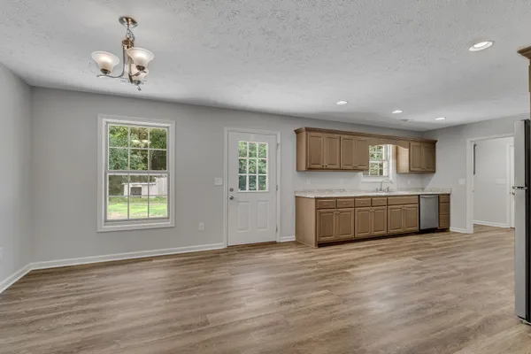 a view of a kitchen with wooden floor and electronic appliances