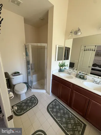a bathroom with a sink a toilet a mirror and shower