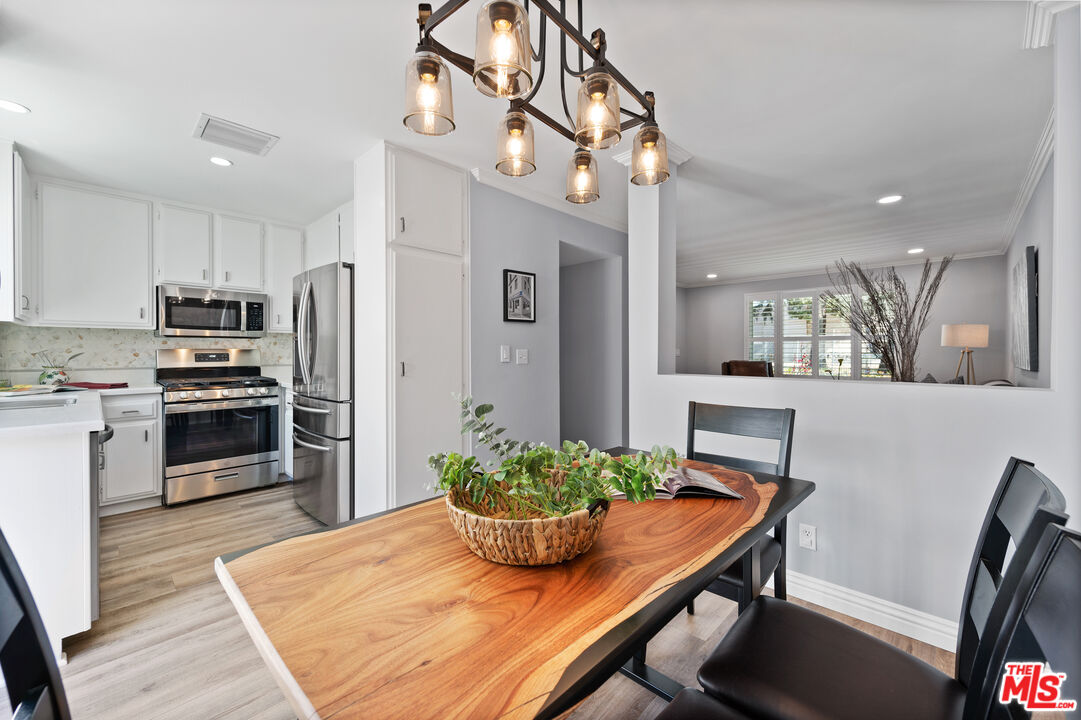 591 Garfield Avenue, Unit 5 Pasadena, CA 91101 - Photo 14 of 48 a kitchen with stainless steel appliances a dining table chairs and refrigerator