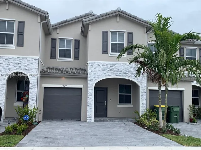 a front view of a house with plants and entryway