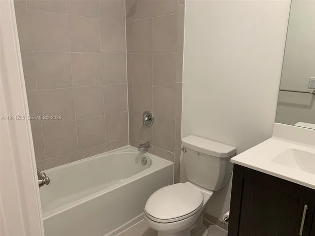 a white toilet and tub next to a bathroom sink