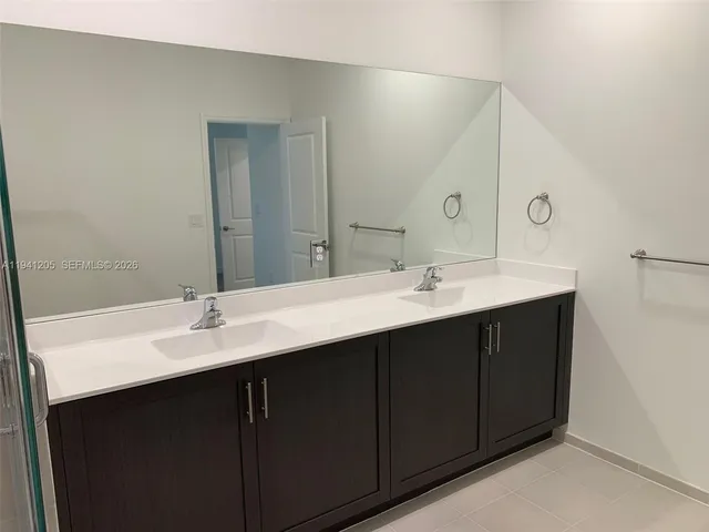 a bathroom with a double vanity sink and mirror