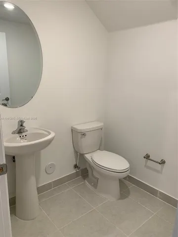a white toilet sitting next to a bathroom sink