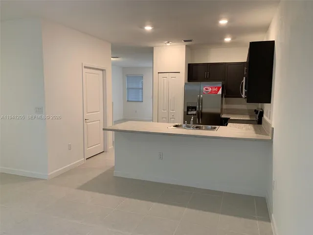a kitchen with stainless steel appliances a refrigerator and microwave