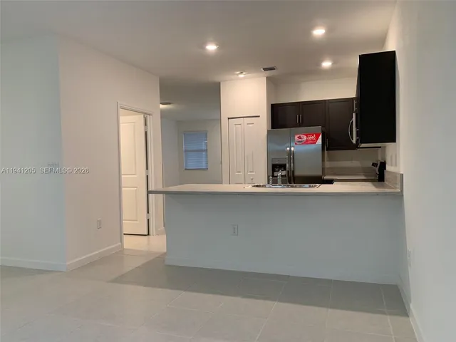 a view of a living room with kitchen furniture and a flat screen tv