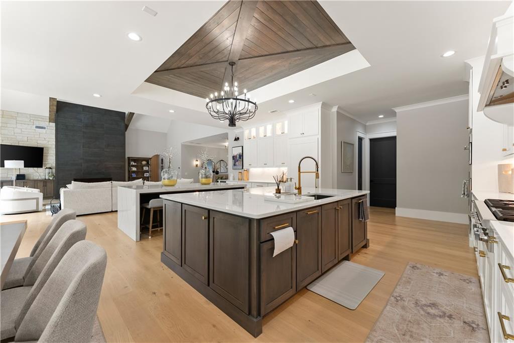373 Fortress Way Jefferson, GA 30549 - Photo 37 of 118 a kitchen with stainless steel appliances granite countertop a sink a stove top oven a chimney and a kitchen island
