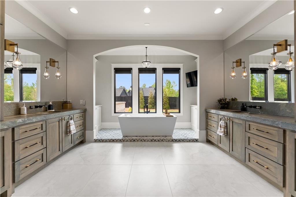 373 Fortress Way Jefferson, GA 30549 - Photo 60 of 118 a large spacious bathroom with a granite countertop tub a double vanity sink a large mirror and a window